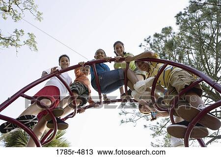 Portrait of children climbing on monkey bars at a playground View Large Photo Image Stock Image - Portrait of children climbing on monkey bars at a playground. Fotosearch