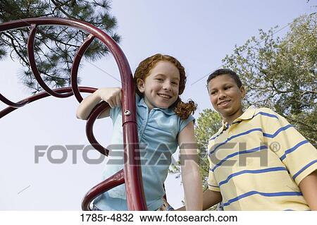 Portrait of children climbing on monkey bars at a playground View Large Photo Image Stock Image - Portrait of children climbing on monkey bars at a playground. Fotosearch
