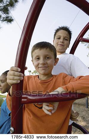 Portrait of children climbing on monkey bars at a playground View Large Photo Image Stock Image - Portrait of children climbing on monkey bars at a playground. Fotosearch