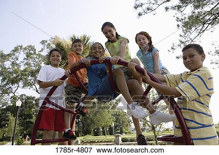 Portrait of children climbing on monkey bars at a playground View Large Photo Image Stock Photo - Portrait of children climbing on monkey bars at a playground. Fotosearch