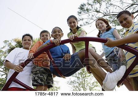 Portrait of children climbing on monkey bars at a playground View Large Photo Image Stock Photo - Portrait of children climbing on monkey bars at a playground. Fotosearch