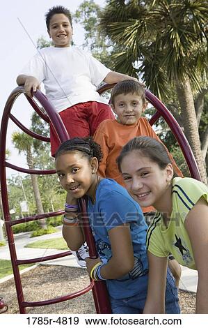 Portrait of children climbing on monkey bars at a playground View Large Photo Image Stock Photo - Portrait of children climbing on monkey bars at a playground. Fotosearch