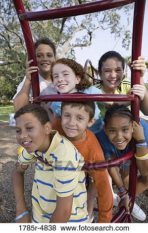 Portrait of children climbing on monkey bars at a playground View Large Photo Image Stock Photo - Portrait of children climbing on monkey bars at a playground. Fotosearch