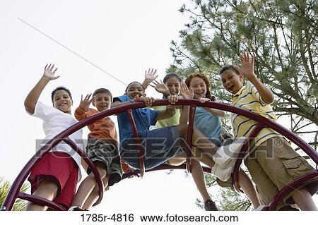 Portrait of children climbing on monkey bars at a playground View Large Photo Image Stock Photograph - Portrait of children climbing on monkey bars at a playground. Fotosearch