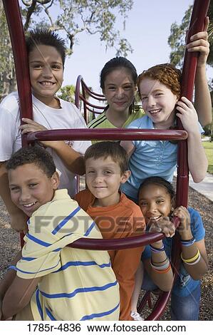 Portrait of children climbing on monkey bars at a playground View Large Photo Image Stock Photograph - Portrait of children climbing on monkey bars at a playground. Fotosearch