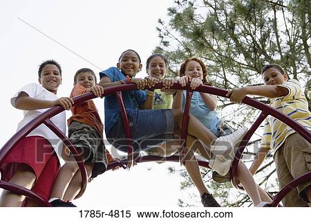 Portrait of children climbing on monkey bars at a playground View Large Photo Image Stock Photography - Portrait of children climbing on monkey bars at a playground. Fotosearch