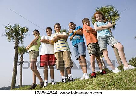 Portrait of children with folded arms standing abreast at a playground View Large Photo Image Picture - Portrait of children with folded arms standing abreast at a playground. Fotosearch