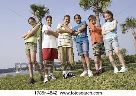 Portrait of children with folded arms standing abreast at a playground View Large Photo Image Stock Image - Portrait of children with folded arms standing abreast at a playground. Fotosearch