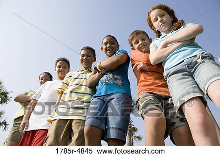 Portrait of children with folded arms standing abreast at a playground View Large Photo Image Stock Photography - Portrait of children with folded arms standing abreast at a playground. Fotosearch