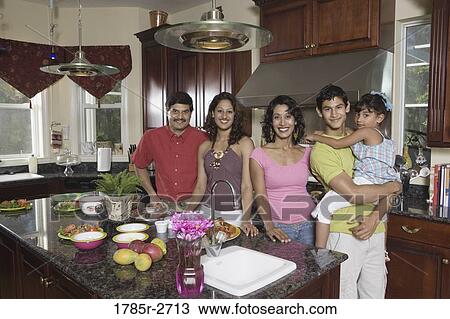 Stock Image - Portrait of extended Indian family in kitchen. Fotosearch