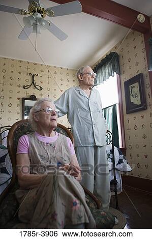 Stock Photograph - Portrait of feeble senior couple in bedroom. Fotosearch