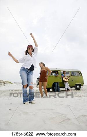 Portrait of hippies dancing and playing guitar on the beach View Large Photo Image Stock Image - Portrait of hippies dancing and playing guitar on the beach. Fotosearch