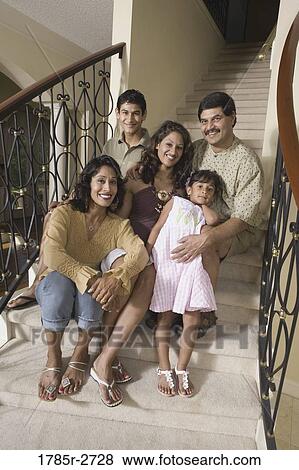 Stock Photo - Portrait of Indian family sitting together on stairs. Fotosearch