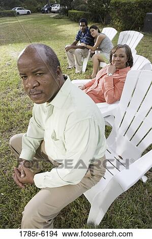 Portrait of interracial couple and parents relaxing in backyard View Large Photo Image Picture - Portrait of interracial couple and parents relaxing in backyard. Fotosearch