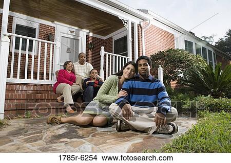 Picture - Portrait of interracial couple and family in front of house. Fotosearch