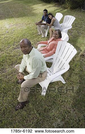 Portrait of interracial couple and parents relaxing in backyard View Large Photo Image Stock Image - Portrait of interracial couple and parents relaxing in backyard. Fotosearch