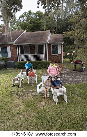 Stock Photo - Portrait of interracial couple and family relaxing in backyard. Fotosearch