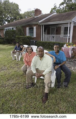 Portrait of interracial couple and family sitting in backyard View Large Photo Image Stock Photo - Portrait of interracial couple and family sitting in backyard. Fotosearch