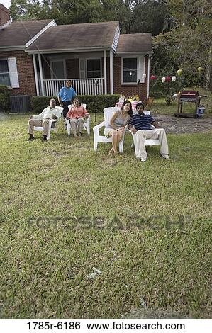 Portrait of interracial couple and family relaxing in backyard View Large Photo Image Stock Photograph - Portrait of interracial couple and family relaxing in backyard. Fotosearch