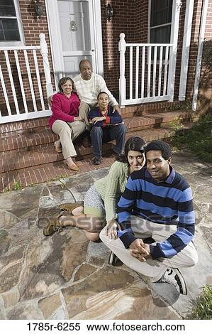 Stock Photography - Portrait of interracial couple and family in front of house. Fotosearch