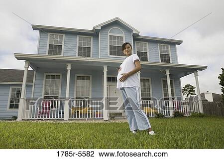 Portrait of pregnant woman standing on lawn in front of house View Large Photo Image Stock Image - Portrait of pregnant woman standing on lawn in front of house. Fotosearch