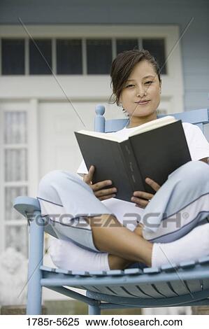 Portrait of pretty young Asian woman sitting on rocking chair reading a book View Large Photo Image Stock Photography - Portrait of pretty young Asian woman sitting on rocking chair reading a book. Fotosearch