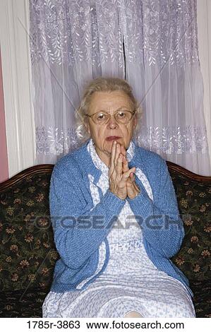 Portrait of senior woman sitting on sofa in living room View Large Photo Image Stock Image - Portrait of senior woman sitting on sofa in living room. Fotosearch