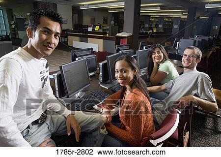 Portrait of students sitting together while using computers in the library View Large Photo Image Stock Image - Portrait of students sitting together while using computers in the library. Fotosearch