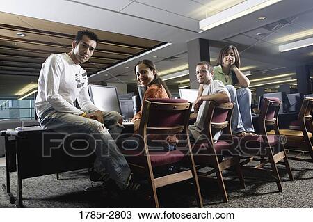 Portrait of students sitting together while using computers in the library View Large Photo Image Stock Image - Portrait of students sitting together while using computers in the library. Fotosearch