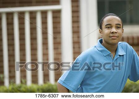 Portrait of teenage boy smiling in front of house View Large Photo Image Stock Photo - Portrait of teenage boy smiling in front of house. Fotosearch