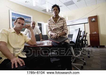 Picture - Portrait of three business people in a conference room. Fotosearch