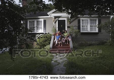 Portrait of two families sitting on the front steps of a house waving US flags View Large Photo Image Stock Image - Portrait of two families sitting on the front steps of a house waving US flags. Fotosearch