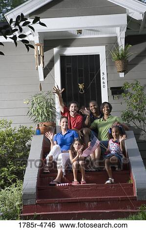 Portrait of two families sitting on the front steps of a house waving US flags View Large Photo Image Stock Photograph - Portrait of two families sitting on the front steps of a house waving US flags. Fotosearch