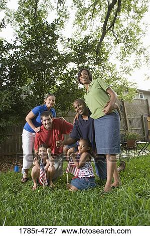 Portrait of two families standing together in backyard of house View Large Photo Image Stock Photo - Portrait of two families standing together in backyard of house. Fotosearch