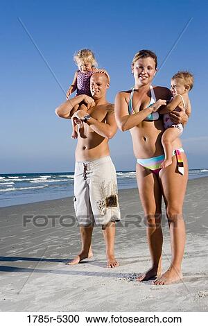 Portrait of young family with young and infant daughters on beach View Large Photo Image Stock Image - Portrait of young family with young and infant daughters on beach. Fotosearch