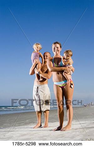 Portrait of young family with young and infant daughters on beach View Large Photo Image Stock Photo - Portrait of young family with young and infant daughters on beach. Fotosearch