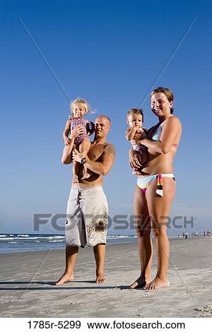 Portrait of young family with young and infant daughters on beach View Large Photo Image Stock Photo - Portrait of young family with young and infant daughters on beach. Fotosearch