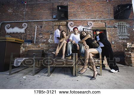 Stock Image - Portrait of young men and women in hip-hop fashion hanging out in a back alley. Fotosearch