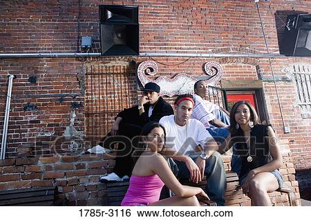 Portrait of young men and women in hip-hop fashion hanging out in a back alley View Large Photo Image Stock Photograph - Portrait of young men and women in hip-hop fashion hanging out in a back alley. Fotosearch