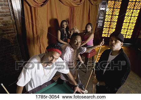 Portrait of young men in hip-hop fashion leaning against pool table View Large Photo Image Picture - Portrait of young men in hip-hop fashion leaning against pool table. Fotosearch