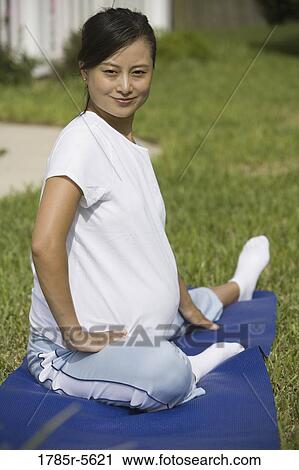 Portrait of young pregnant Asian woman doing stretching exercises View Large Photo Image Stock Image - Portrait of young pregnant Asian woman doing stretching exercises. Fotosearch