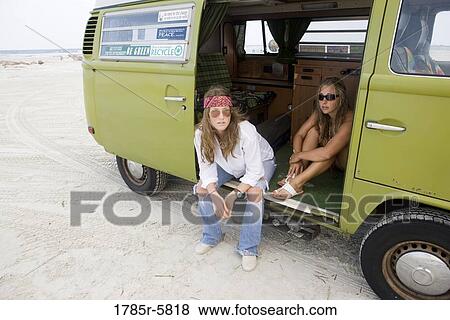 Stock Photo - Portrait of young women in hippie fashion sitting in a van at beach. Fotosearch