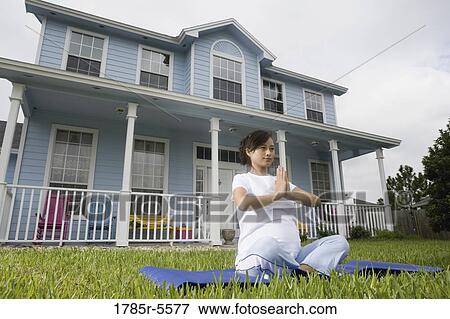 Pregnant woman in a yoga position in front of house View Large Photo Image Stock Photo - Pregnant woman in a yoga position in front of house. Fotosearch