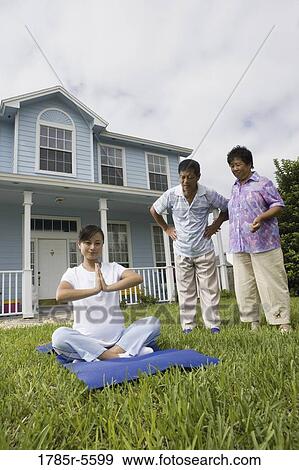 Pregnant woman in a yoga position while her parents stand by and watch View Large Photo Image Stock Photo - Pregnant woman in a yoga position while her parents stand by and watch. Fotosearch