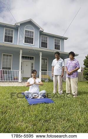 Stock Photography - Pregnant woman in a yoga position while her parents stand by and watch. Fotosearch