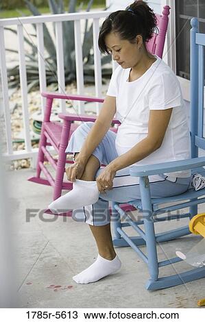 Pregnant woman putting on socks View Large Photo Image Stock Image - Pregnant woman putting on socks. Fotosearch