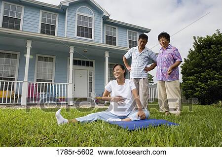 Pregnant woman sitting on mat and laughing while her parents stand by and watch View Large Photo Image Stock Image - Pregnant woman sitting on mat and laughing while her parents stand by and watch. Fotosearch