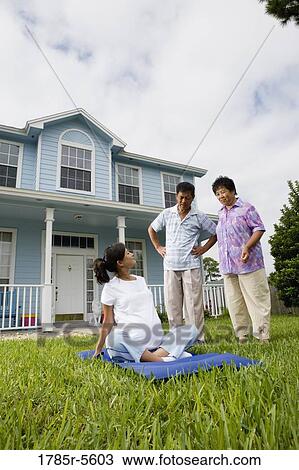 Pregnant woman sitting on mat while her parents stand by and watch View Large Photo Image Stock Image - Pregnant woman sitting on mat while her parents stand by and watch. Fotosearch