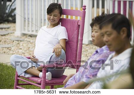 Pregnant woman sitting on rocking chair with her parents in foreground View Large Photo Image Stock Image - Pregnant woman sitting on rocking chair with her parents in foreground. Fotosearch
