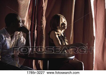 Stock Photo - Profile of young couple in dimly lit room. Fotosearch